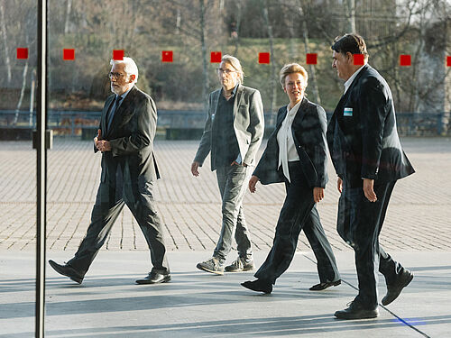 Ministerin Ina Brandes Oberbuergermeister Joerg Lukat Rektor Martin Paul und Eike Kiltz vor der Jahrhunderthalle laufend fotografiert durch die Scheibe 