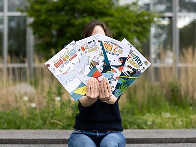 Person hält vier Comics in der Hand
