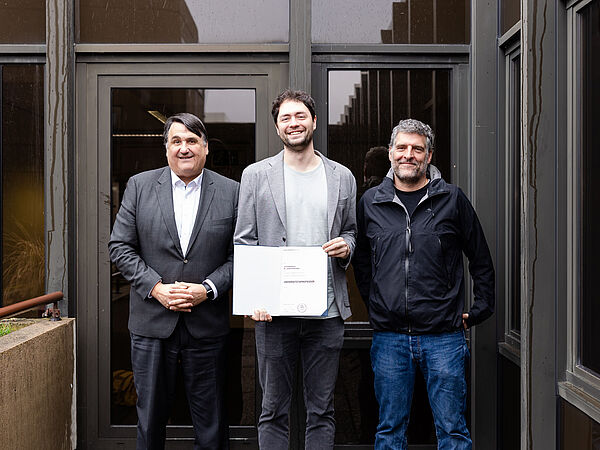 Rektor Dr. Martin Paul, Jonas Haferkamp und Dekan Prof. Dr. Gregor Leander beim Verleih der Professur. 