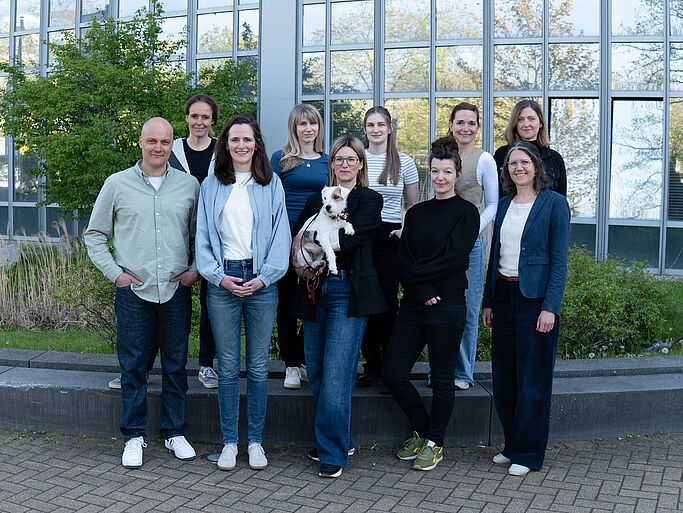 The CASA Team: A group of nine people stand in front of the building MC at RUB.